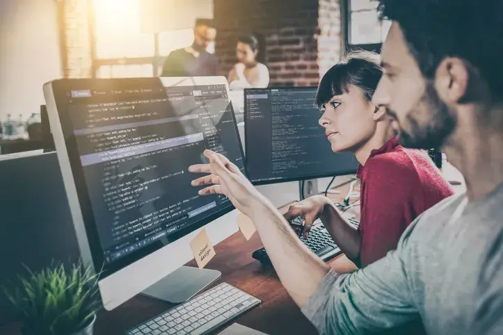 Two people sit in front of the computer screen and see how easily VeriFactu API by fiskaly adapts
