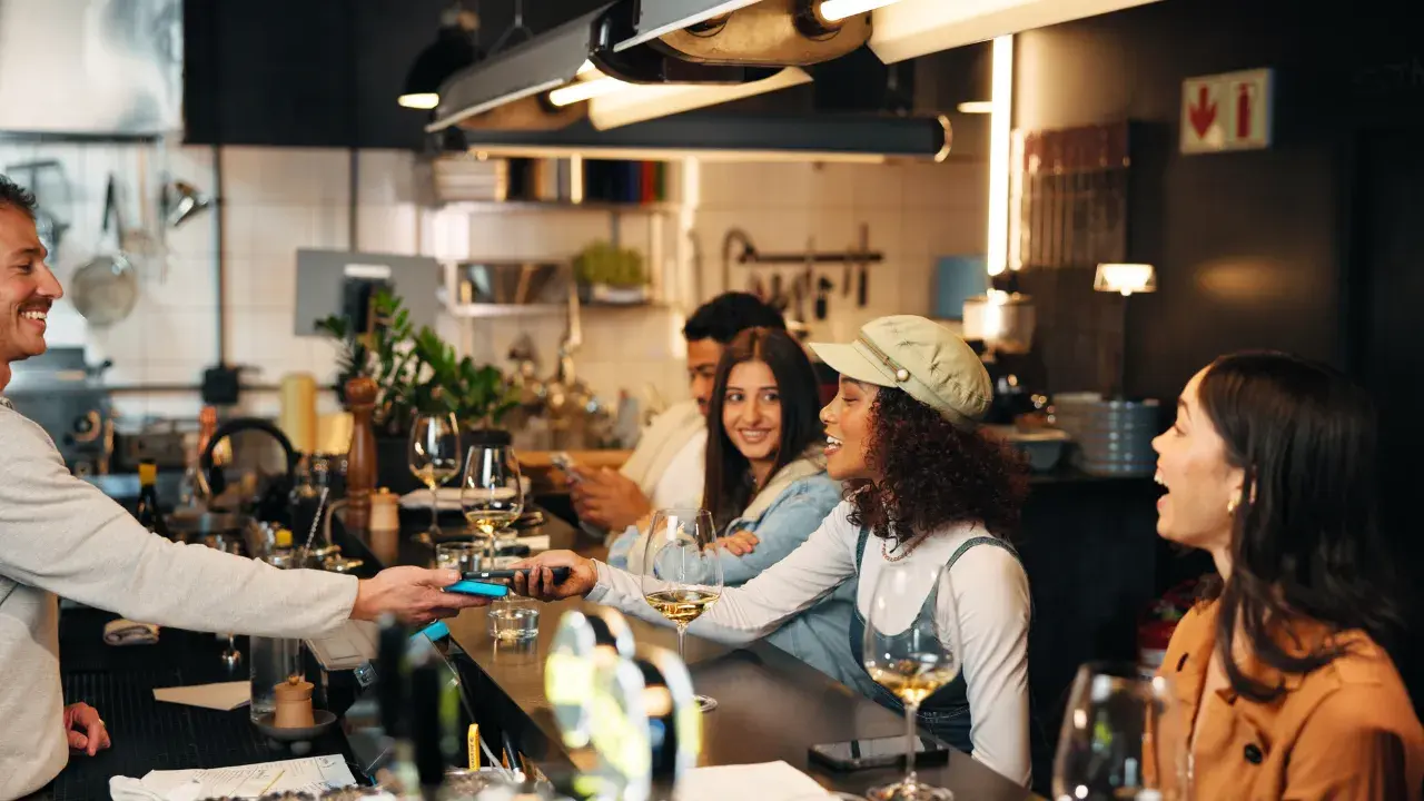 Customers at a bar making a card payment using a payment terminal connect to fiscal device.